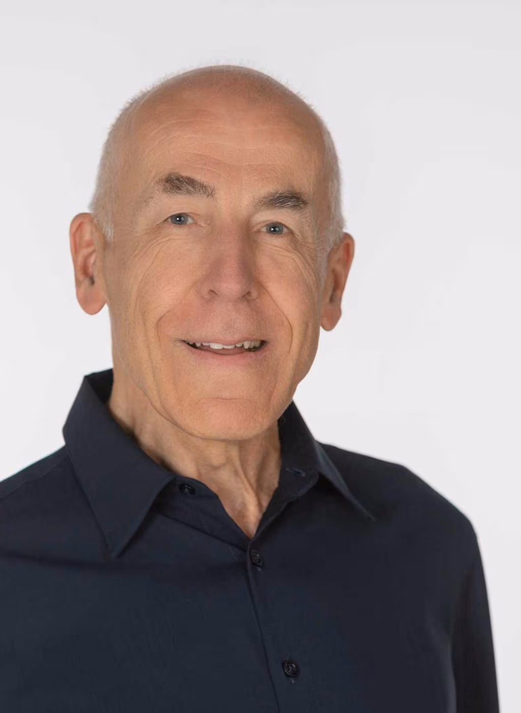 Porträtfoto von Dr. Bernward Gall, sitzend und lächelnd,
				vor neutralem Hintergrund.